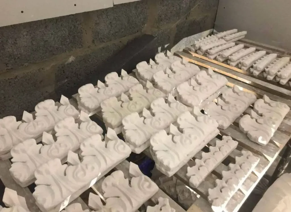 Rows of ornate replacement cornice sections drying on racks – classic design Glasgow