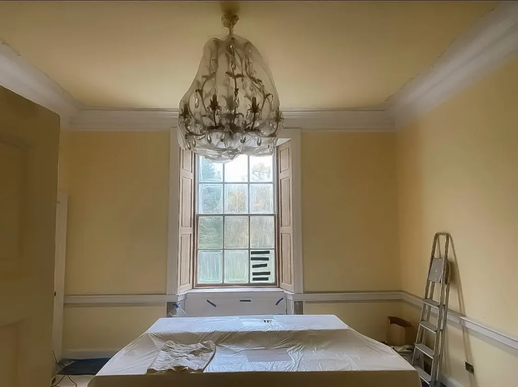 Restored decorative plaster cornice around ceiling edge in completed room – original cornice repairs