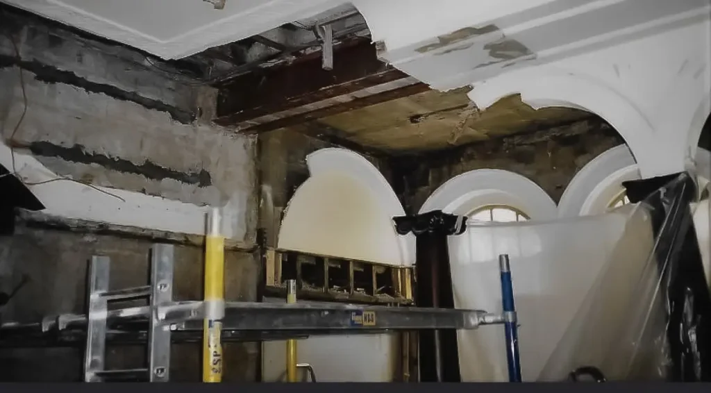 Damaged interior ceiling area with arched windows and scaffold during plaster restoration – classic design Glasgow