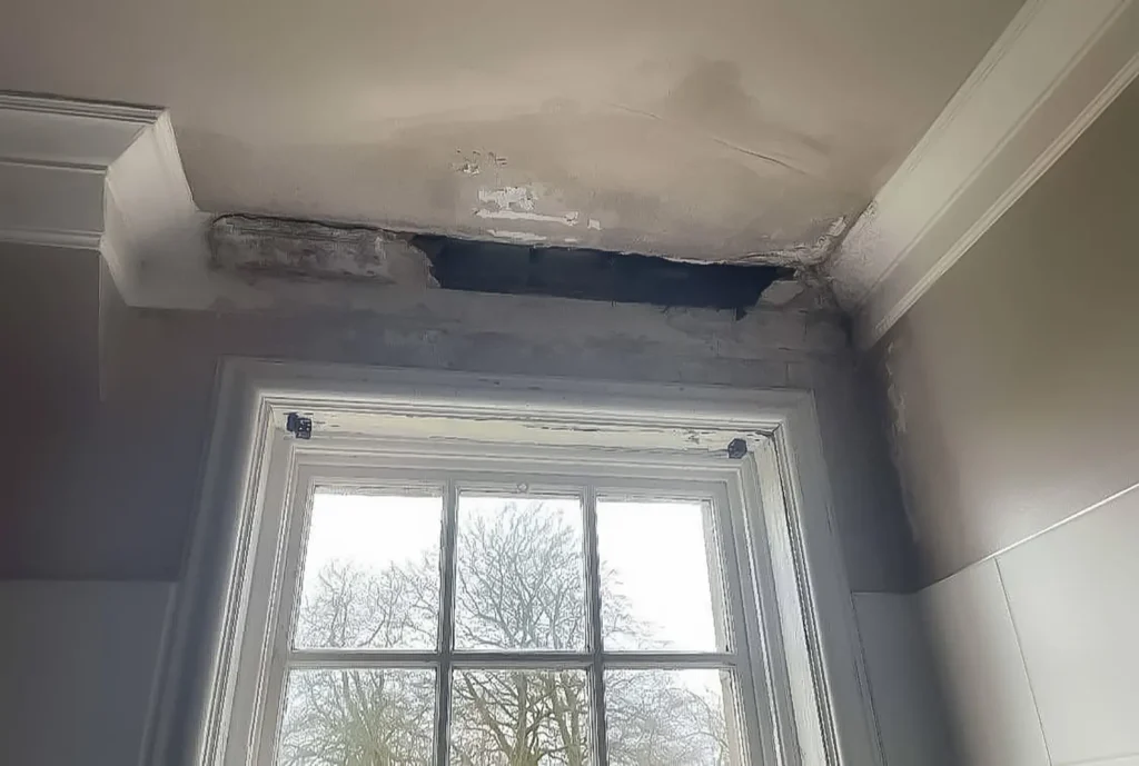 Ceiling above window with exposed lath and cracked plaster – water damaged ceiling, Glasgow