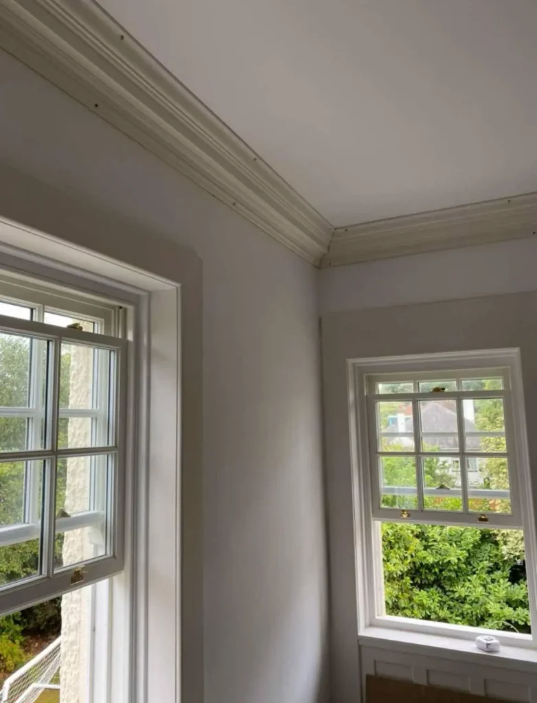 Plaster coving installed around ceiling corners above windows – cornice installation Glasgow