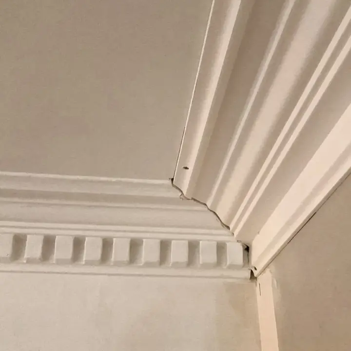 New plaster cornice being precisely aligned with existing section during installation – Cornice installation – Glasgow
